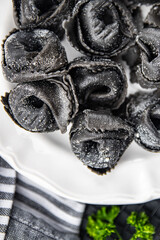 ravioli black agnolotti color cuttlefish ink fresh seafood salmon fish cooking appetizer meal food snack on the table copy space food background rustic top view