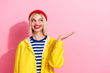 Photo of looking stylish fashion model new collection yellow raincoat warm hat holding arm empty space isolated on pink color background