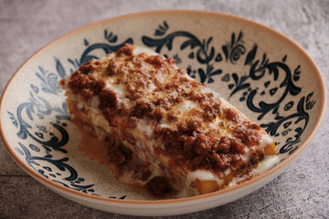Italian Comfort: A generous slice of lasagna, its layers of pasta, rich meat sauce, creamy béchamel, and melted cheese melded into a perfect harmony, a taste of traditional Italian comfort that warms 