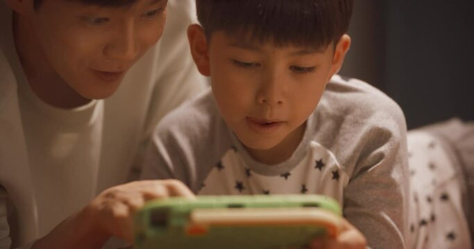 태블릿으로 하던 학습 게임을 클리어한 아빠와 아들의 상반신 영상