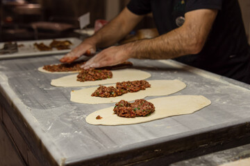Man cooks Turkish tortillas with meat. Soft focus. Kitchen in a hotel, cafe or restaurant