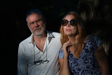 Obraz premium Portrait of a woman and a man. A couple. A woman with long blond hair. The woman is dressed in a blue dress. Silver necklace. The man is dressed in a white shirt.