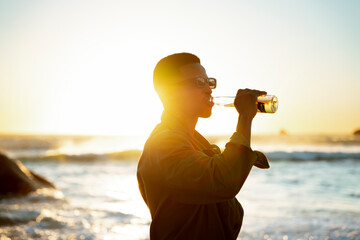 A Man Drinking A Beer at Sunset on the Beach