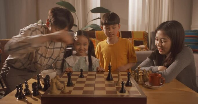 거실에서 체스 게임을 하는 부자와 둘을 도와주는 모녀의 상반신 영상