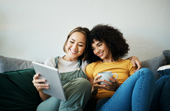 Relax, happy and a lesbian couple with a tablet on the sofa for social media, internet or a movie. Coffee, house and gay or lgbt women with technology for streaming a film or show on the couch