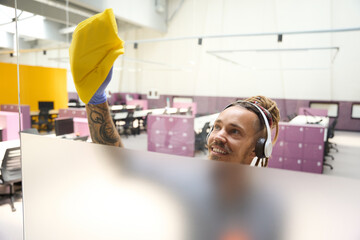 Cleaner in headphones rubs the transparent partition with yellow rag