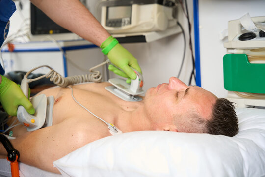 Paramedic applies defibrillator electrodes to a patients torso