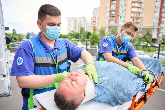 Colleagues of paramedics fix the victim on a special wheelchair