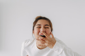 Happy asian Thai cute silly woman laughing loud giggle, covering mouth, look at empty space,...