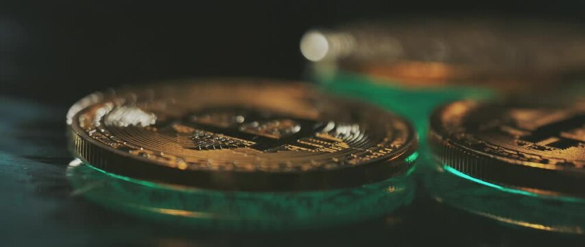 Row of Bit Coins, Horizontal. Wide macro lens extreme close up shot of golden bitcoin medallions with a capital B (?) symbol and circuit design
