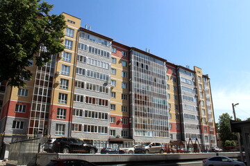 There is a high-rise building with parking and cars.