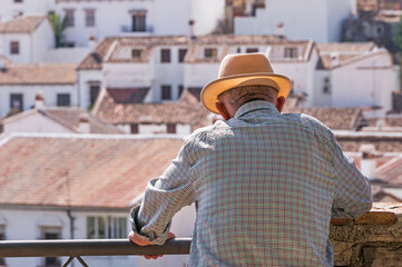 Senior man with straw hat looking at his village