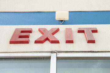exit word caption writing text in red sign on building wall above windows with turned off light...