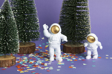 an astronaut figurine in a spacesuit exploring a forest of snowy fir trees