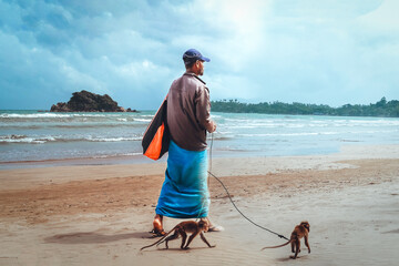man walking along  beach with  monkey  leash, highlighting harsh reality  animal...