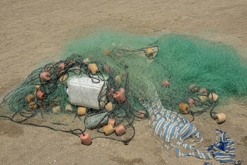 Zihuatanejo, Mexico - July 18, 2023: Playa Larga. Closeup of green fishing net with floaters on sand