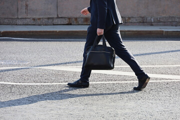 Man in a business suit walking down the street with briefcase in hand