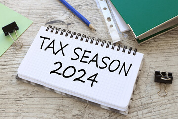TAX 2024 . blue pencil points to text on notebook - obrazy, fototapety, plakaty