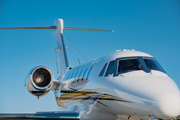 Small corporate jet as seen from the side. Fuselage, wings, tail-fin and the jet engine are...