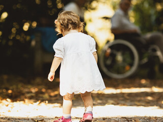 Ein kleines Mädchen in weißem Kleid im Park