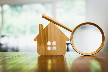 Magnifying glass and house model, house selection, real estate concept.	