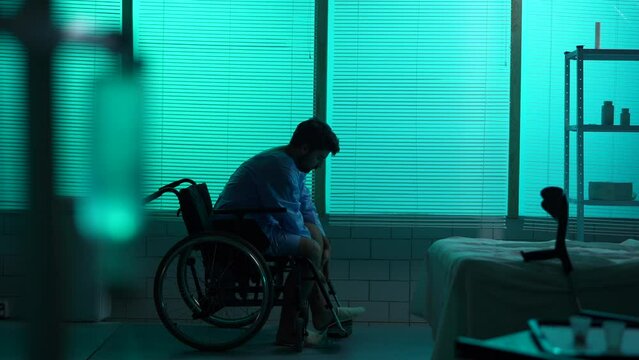 Full-sized silhouette video of a disabled man, patient with mobility impairment trying to get up from a wheelchair, making a few succesful steps.