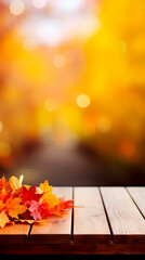 Autumn or Thanksgiving background with rustic wooden planks, leaves and yellow, orange fall colors on the blurred-out trees on the background. Texture with copy space.
