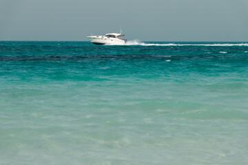 Blue clear sea, yacht, water, waves, clear sky. beach in Saadiyat island, United Arab Emirates. Beautiful seascape.