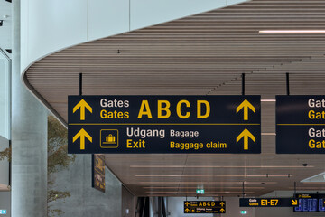 airport terminal sign (gate a b c d exist) english and danish in Copenhagen (modern, directional) white ceiling - obrazy, fototapety, plakaty