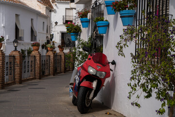 Fototapeta na wymiar Una moto roja aparcada en una calle de Andalucía