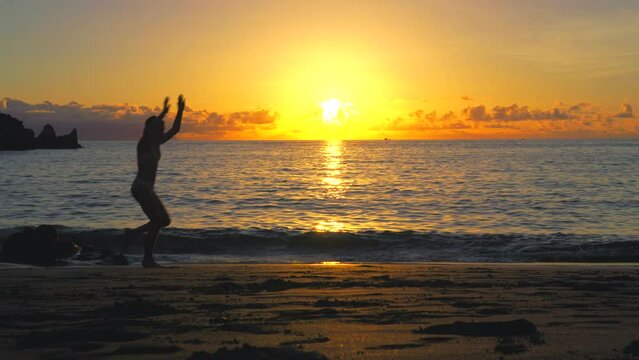 silhouette of a woman running on the beach at sunset
