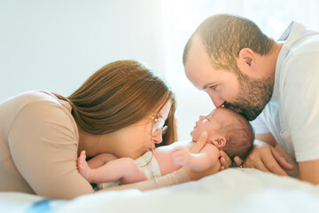father and mother on bedroom with his newborn baby son