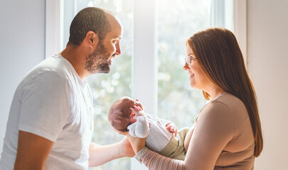 father and mother on bedroom with his newborn baby son