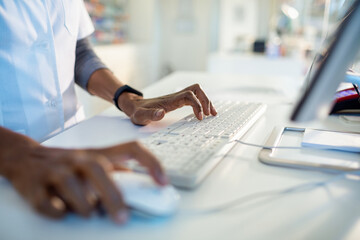 Close up of a pharmacist working on the computer in a pharmacy
