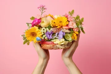 Foto op Canvas Woman holding flower sandwich on pastel background Spring or summer theme © The Big L