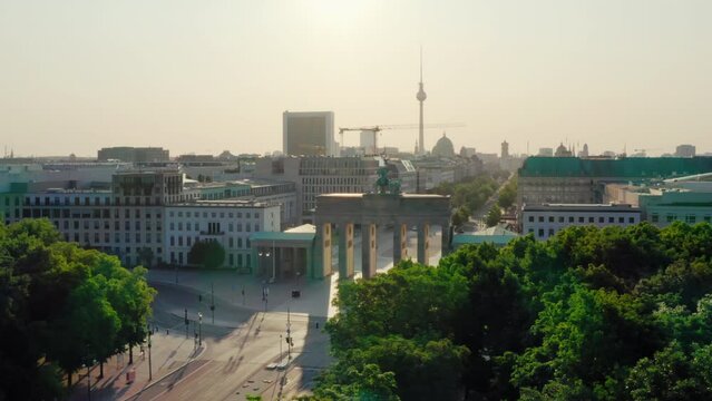 Establishing Aerial shot of Berlin Skyline, capital of Germany, EU. Brandenburg City Gate and TV Tower as Main touristic landmarks. 4K drone panoramic footage of iconic urban cityscape on sunrise