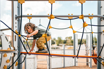 portrait of happy little boy learning and playing on playground walkway - Powered by Adobe