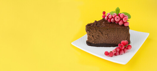 Piece of chocolate cheesecake on the white plate on the yellow background. Copy space.
