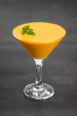 Carrot cream jelly dessert, Panna Cotta in martini glass. Dark background