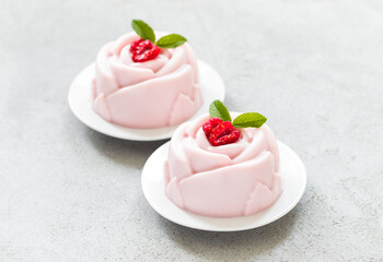 Vegan Raspberry cream dessert pudding in the shape of a rose, on a plate. Close up