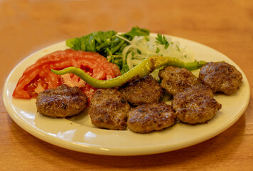 grilled meatballs with grilled tomato, onion and pepper
