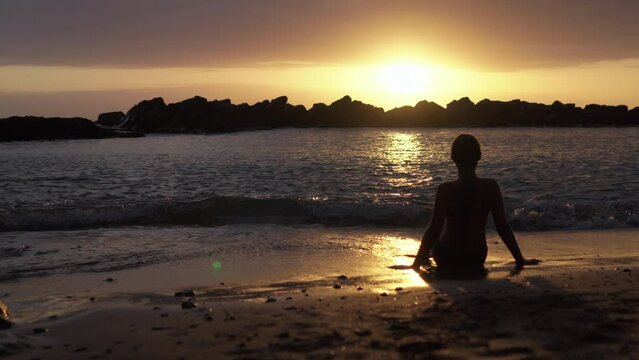 young girl enjoying sunset at the beach