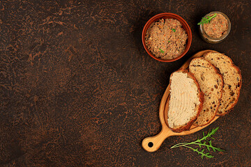 Homemade whole grain bread with chicken pate and arugula on a concrete background, the concept of a...