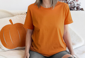 Burnt Orange t shirt mockup with copy space. Girl wearing orange  tshirt template with pumpkin...