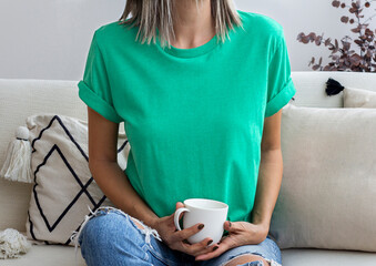 Women wearing blank heather green tshirt with copy space for your text or design with coffee cup. Christmas holiday tshirt mock up