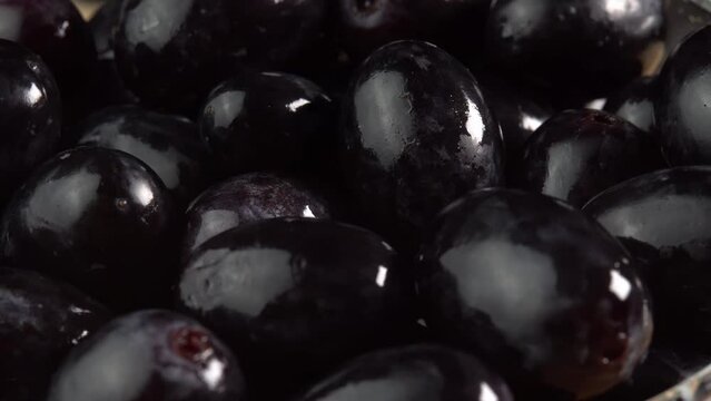 Grape close up, concept winemaking, wine production, vine variety. Fresh bunches of grapes of black sort rotate as a background