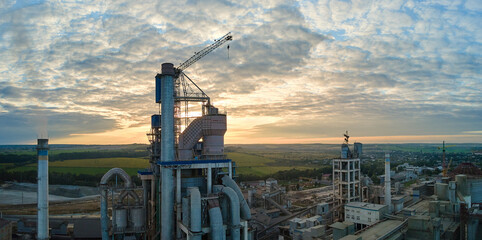 Aerial view of cement factory under construction with high concrete plant structure and tower...
