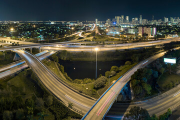 View from above of american big freeway intersection in Miami, Florida at night with fast moving cars and trucks. USA transportation infrastructure concept