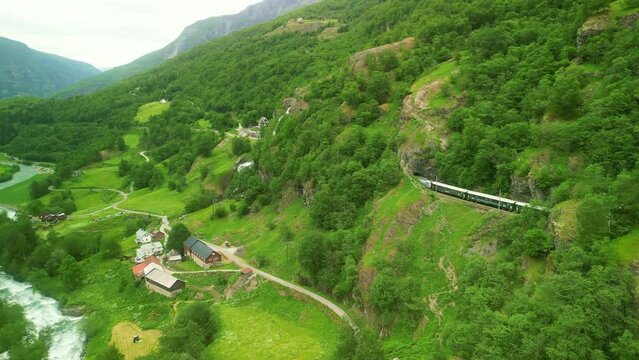 Aerial drone Norway landscape. Flamsbana train on Flam Railway. Mountains and waterfalls of Norway in summer. Famous train adventure for cruise ship tourists in Flam. 