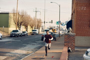 Young man jogging beside a road in the city